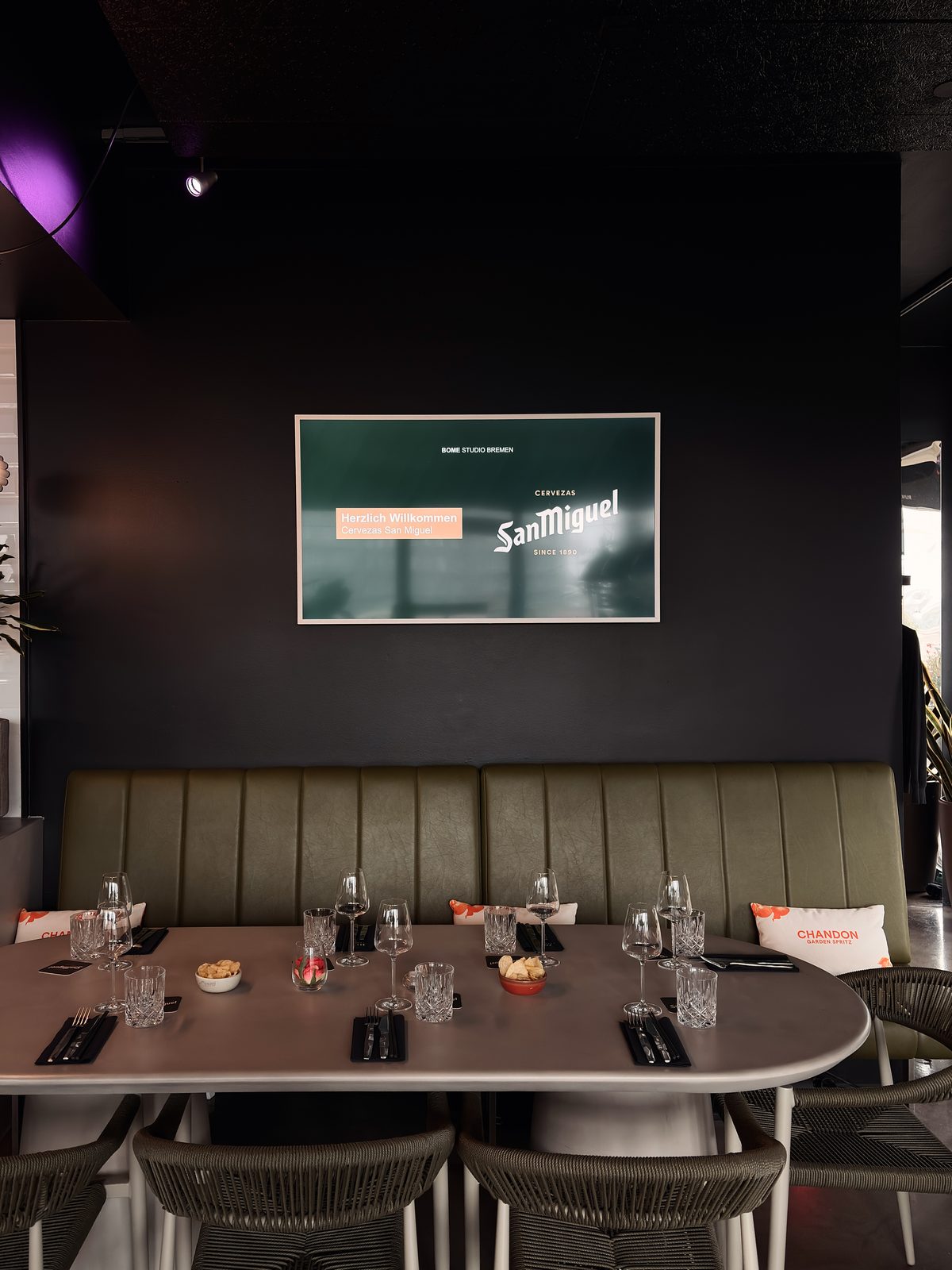 Willkommensbildschirm mit dem Logo eines Gastunternehmens über der eingedeckten Tafel